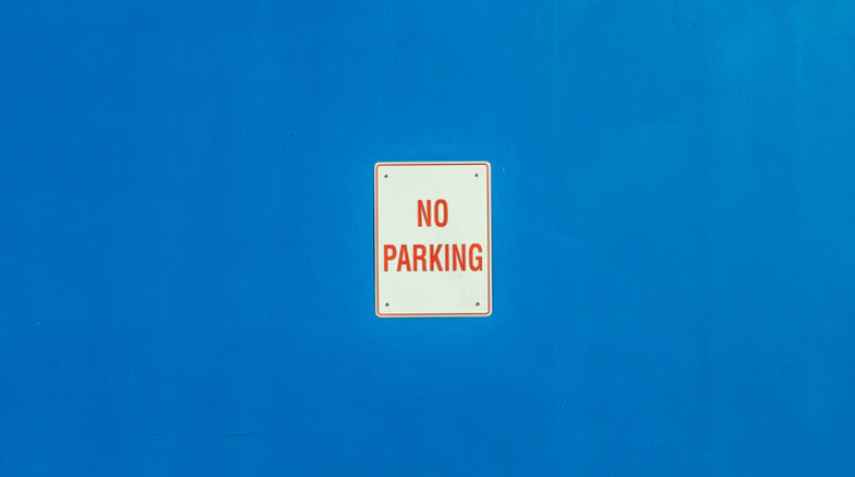 No parking sign on blue wall